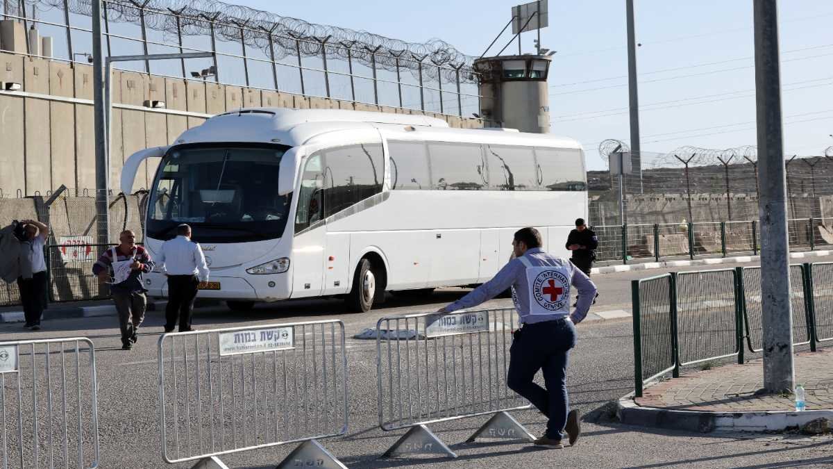 Un bus de la Cruz Roja Internacional espera en un campo militar después de trasladar a los primeros presos palestinos liberados por Israel. Foto: Ahmad Gharabli / AFP.