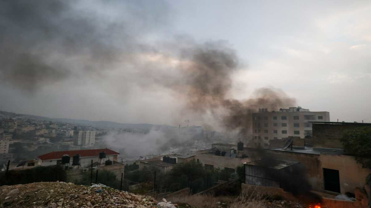 Columnas de humo se levantan sobre el campo de refugiados de Jenin, en Gaza. Foto: Jaafar Ashtiyeh / AFP.