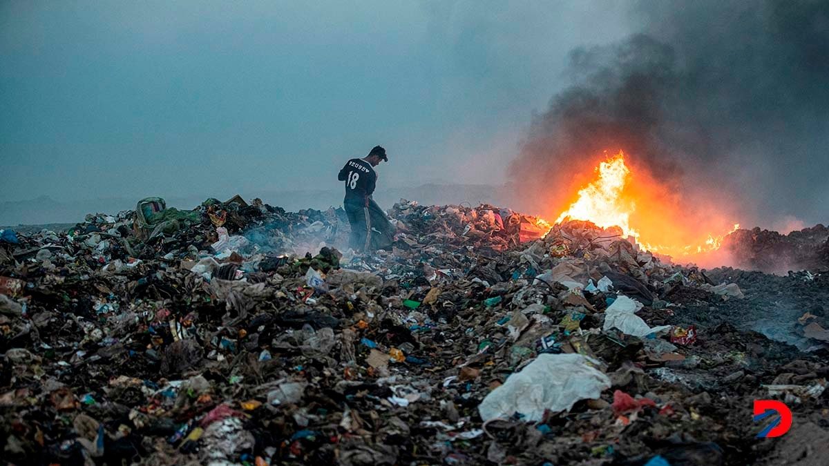 Un joven busca materiales reciclables en medio de toneladas de desechos. Foto: Hussein Faleh / AFP.