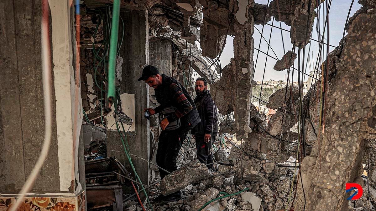 Algunas personas inspeccionan lo que quedó de un edificio destruido por un bombardeo israelí en Rafah, al sur de Gaza. Foto: Said Khatib / AFP.