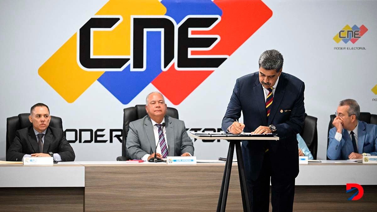 El presidente de Venezuela, Nicolás Maduro, firma el documento de compromiso que elaboró el CNE, y que solo suscribieron junto a él las agrupaciones minoritarias. Foto: Federico Parra / AFP.