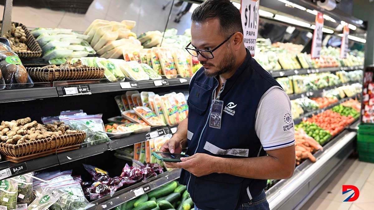 Un inspector de la Defensoría del Consumidor de El Salvador revisa los precios de diferentes frutas y vegetales en un supermercado privado. Foto: Marvin Recinos / AFP.