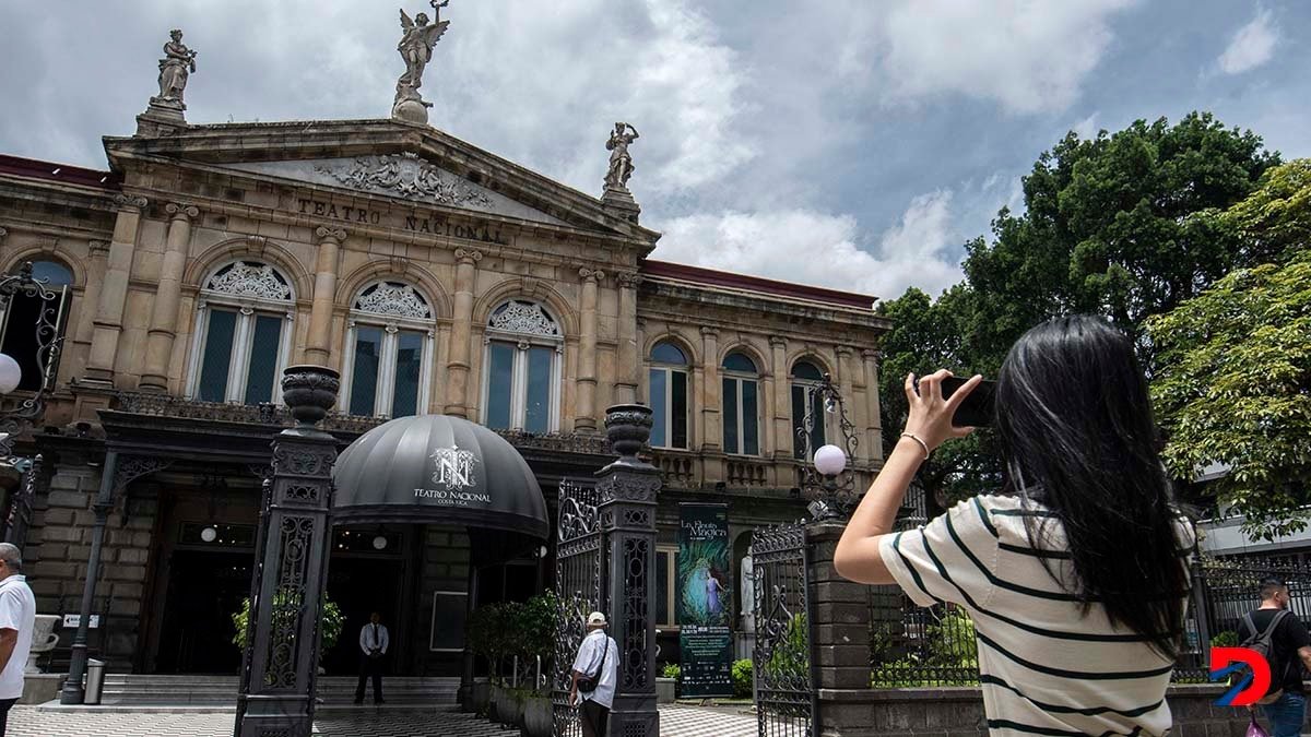 Una turista toma una fotografía del Teatro Nacional, el jueves. Las cifras de llegada de turistas al país en el primer semestre del año son positivas. Foto: Ezequiel Becerra / AFP.