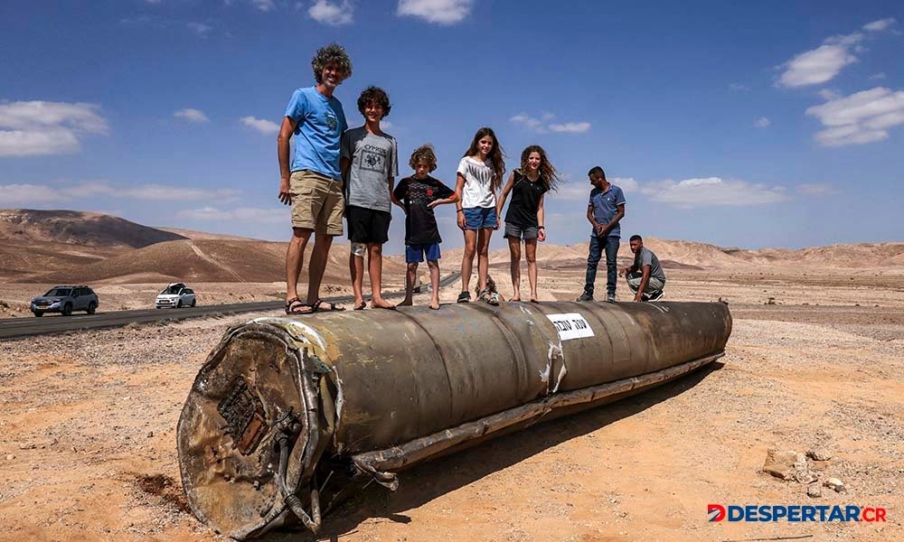 Algunas personas observan los restos de un misil iraní, en el desierto de Neguev, cerca de la ciudad de Arad. Foto: Menahem Kahana / AFP.